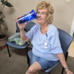 A UCHRA Public Transportation employee poses with a blue tumbler, featuring the UCHRA Public Transportation logo.