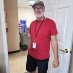 A UCHRA Public Transportation employee poses with a blue tumbler, featuring the UCHRA Public Transportation logo.